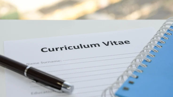 CV incomplet posé à côté d'un stylo et d'un carnet de notes
