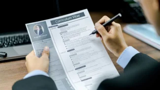 Recruteur qui lit attentivement un CV aux couleurs grises