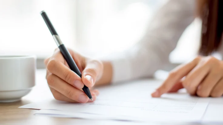 Candidate qui relit attentivement son CV avant d'écrire sa lettre de motivation