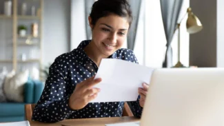 Candidate qui lit une lettre de recommandation avec le sourire aux lèvres