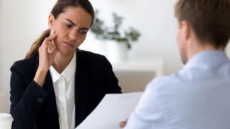Recruteuse qui lit le CV d'un candidat et laisse paraître ses doutes