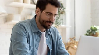 Candidat qui consulte des informations sur son ordinateur dans sa cuisine