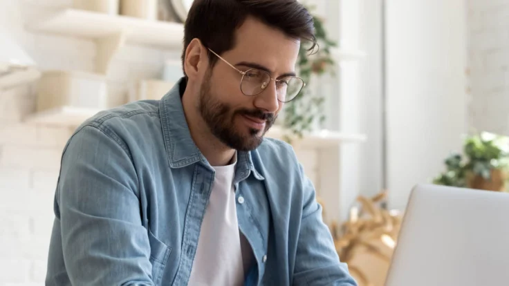 Candidat qui consulte des informations sur son ordinateur dans sa cuisine