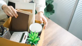 Employée qui range son bureau après avoir démissionné pour se reconvertir